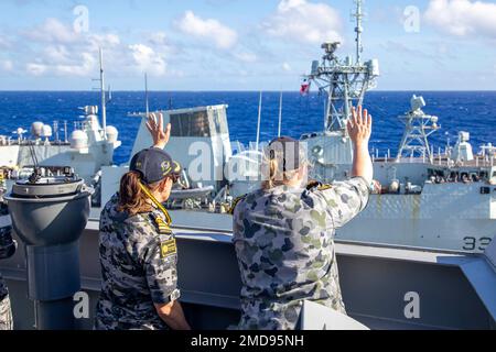 PAZIFIK (15. Juli 2022) Royal Australian Navy Hilfsöler Nachfüllschiff HMAS Supply (A 195) Befehlshaber, Commander. Cindy Jenkins (links) und Navigator LT. Cmdr. Jacqueline Rushford (rechts) winkt der königlichen kanadischen Fregatte HMCS Winnipeg (FFH 338) bei der Fertigstellung einer Wiederauffüllung auf See während des Rim of the Pacific (RIMPAC) 2022 zu. Von Juni 29 bis August 4 nehmen an der RIMPAC 25.000 Nationen, 38 Schiffe, vier U-Boote, mehr als 170 Flugzeuge und Mitarbeiter auf und um die hawaiianischen Inseln und Südkalifornien Teil. Die weltweit größte internationale Seeverkehrsbranche Stockfoto