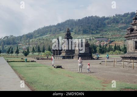 Banjarnegara, Indonesien - 20. Januar 2023: Touristen besuchen den Candi Arjuna Hindu-Tempel auf dem Dieng-Plateau. Stockfoto