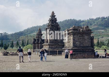 Banjarnegara, Indonesien - 20. Januar 2023: Touristen besuchen den Candi Arjuna Hindu-Tempel auf dem Dieng-Plateau. Stockfoto