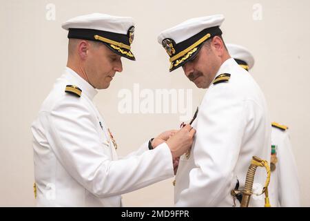 Kapitän Gary Montalvo Jr., Befehlshaber des U-Boot-Entwicklungsgeschwaders (DEVRON) 5, verleiht dem Commander die Medaille für verdienstvolle Dienste. Robert Patchin, kommandierender Offizier, Unbemannte Unterwasserfahrzeugstaffel (UUVRON) 1, während einer Zeremonie, mit der UUVRON-1 zum Hauptkommando der U-Boot-Streitkräfte erhoben und Unbemannte Unterwasserflotte (UUV Flotilla) 1 als untergeordnetes Kommando am Marinestützpunkt Kitsap-Keyport, Washington, 14. Juli 2022, eingerichtet wurde. Die Zeremonie war auch ein Befehlswechsel für UUVRON-1, wobei Captain Jason Weed Patchin ablöste. Stockfoto