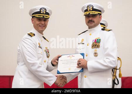 Captain Gary Montalvo Jr., Left, Commander, Submarine Development Squadron (DEVRON) 5, überreicht die Meritorious Service Medaille an Commander. Robert Patchin, kommandierender Offizier, Unbemannte Unterwasserfahrzeugstaffel (UUVRON) 1, während einer Zeremonie, mit der UUVRON-1 zum Hauptkommando der U-Boot-Streitkräfte erhoben und Unbemannte Unterwasserflotte (UUV Flotilla) 1 als untergeordnetes Kommando am Marinestützpunkt Kitsap-Keyport, Washington, 14. Juli 2022, eingerichtet wurde. Die Zeremonie war auch ein Befehlswechsel für UUVRON-1, wobei Captain Jason Weed Patchin ablöste. Stockfoto