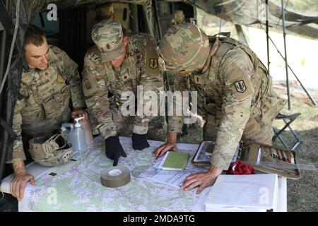 Der hochrangige Berater des 1. Bataillons, des 6. Artilleriegesiments, des 41. Kommandostabs der Artilleriebrigade, Major Tyler. Bell und Soldaten besprechen Bewegungspläne während der Übung Dynamic Front 22 im Trainingsbereich Hohenfels, Deutschland, 17. Juli 2022. DF-22, angeführt vom 56. Artilleriekommando und den USA Unter der Regie der Armee Europa und Afrika ist die erste von den USA angeführte, von den NATO-Alliierten und -Partnern integrierte Feuerübung im europäischen Theater, die sich auf die Interoperabilität von Bränden und die Verbesserung der Bereitschaft, der Letalität und der Interoperabilität in den Bereichen Mensch, Verfahren und Technik konzentriert. Stockfoto