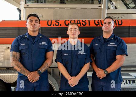 Petty Officer 2. Class Jarrett Guerra, Petty Officer 3. Class Corey Connolly und Petty Officer 2. Class Jake Flores, Mitglieder des Coast Guard Maritime Safety & Security Team Houston, posieren für ein Foto im Bootshaus der Einheit in Houston, Texas, 14. Juli 2022. Während sie am 2. Juni 2022 im Rio Grande stationiert waren, retteten Guerra, Connolly und Flores zwei Erwachsene Frauen und einen 1-jährigen Jungen vor dem Ertrinken im Fluss. Stockfoto