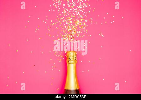 Festliches Partykonzept, Champagnerflasche mit Konfetti-Glitzer, farbenfrohe Sterne auf pinkfarbenem Hintergrund. Stockfoto