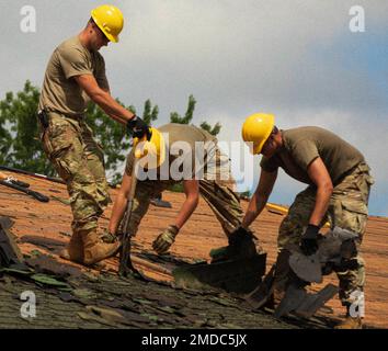 Soldaten der Illinois Army National Guard entfernen mit der 661. Engineer Company, 123. Engineer Battalion mit Sitz in Macomb, Illinois, Asphaltschindeln aus dem Wellnesscenter, bevor am 15. Juli 2022 in Camp Ripley, Minnesota, ein neues Stahldach installiert wird. Stockfoto