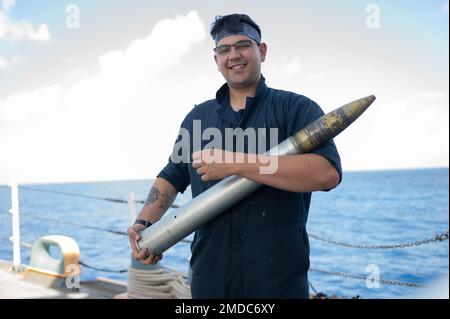 Gavin Alatar, ein Kamerad an Bord des Küstenwache Cutter Bear (WMEC 901), posiert für ein Umweltporträt mit einer 76-mm-Munition, Atlantik, 15. Juli 2022. Der Bär und seine Besatzung setzen sich ein, um die Organisation für die Fischerei im Nordatlantik zu unterstützen, illegale Fischerei abzuschrecken und das Bewusstsein für den maritimen Bereich gemeinsam mit seinen verbündeten Nationen zu erhöhen. Cutter, Patrol, USCG, USCGC Bär, unterwegs, Stockfoto