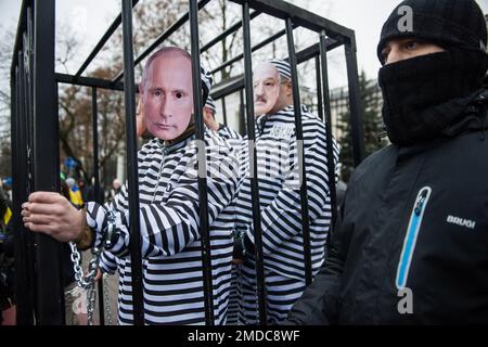 Wladimir Putin, Sergeei Shoigu, Sergej Lawrow und Aleksander Lukaschenko werden symbolisch in einem Käfig wie Kriegsverbrecher während des Protests außerhalb der russischen Botschaft verschlossen gesehen. Hunderte Menschen, vor allem ukrainische Flüchtlinge in Polen, blockierten die Straße vor der russischen Botschaft in Warschau, um den Tag der Einheit der Ukraine zu begehen und gegen die russische Invasion in der Ukraine zu protestieren. Die Demonstranten richteten ein symbolisches Kriegsverbrechertribunal für den russischen Präsidenten ein - Wladimir Putin, der Verteidigungsminister Sergej Shoigu, der Außenminister Russlands Sergej Lawrow und der Präsident von Belarus - Aleksa Stockfoto