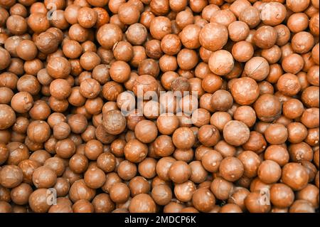 Macadamia-Nuss-Struktur Hintergrund, frische, natürlich geschälte rohe Macadamia-Nüsse im Vollformat, Nahaufnahme von gebratenen Macadamia-Nüssen - Draufsicht Stockfoto