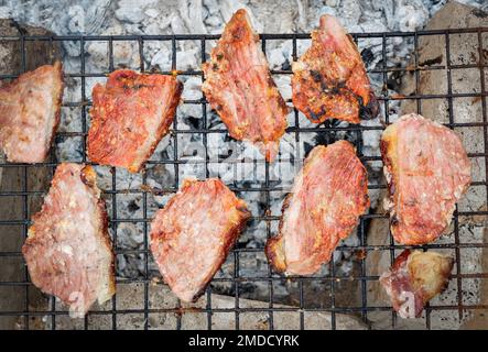 Gegrillte Schweinesteaks, Schweinenacken mit Salz auf dem Grill, einheimisches Essen in ländlichem asien, gegrilltes Fleisch, barbecue, Schweinebraten, Street Food - Draufsicht Stockfoto