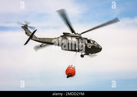 Eine Oklahoma Army National Guard UH-60 Black Hawk fliegt über das Feuer von 702 in Blaine County, Oklahoma, nachdem sie am 16. Juli 2022 mehr als 600 Gallonen Wasser auf das Feuer geworfen hat. Die Oklahoma National Guard unterstützt die Oklahoma Forestry Services und die örtlichen Feuerwehren aus der Luft mit einem UH-60 Black Hawk und einem LUH-72 Lakota. (Foto der Oklahoma National Guard von Sgt. Anthony Jones) Stockfoto