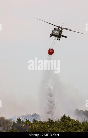 Eine Oklahoma Army National Guard UH-60 Black Hawk lässt beim Brand 702 in Blaine County, Oklahoma, 16. Juli 2022 mehr als 600 Gallonen Wasser fallen. Die Oklahoma National Guard unterstützt die Oklahoma Forestry Services und lokale Feuerwehren bekämpfen den Brand von oben mit einem UH-60 Black Hawk und LUH-72 Lakota. (Foto der Oklahoma National Guard von Sgt. Anthony Jones) Stockfoto