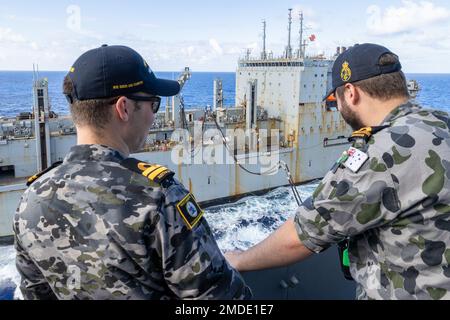 PAZIFIK (22. Juli 2022) Royal Australian Navy LT. Cameron Morgan und Sub LT. William Payne beobachten während des Rim of the Pacific (RIMPAC) 2022 eine Wiederauffüllung auf See zwischen der Royal Australian Navy Landing Helikopter Dock HMAS Canberra (L02) und dem Trockenschiff USNS Washington Chambers (T-AKE 11) der Lewis- und Clark-Klasse. Von Juni 29 bis August 4 nehmen an der RIMPAC 25.000 Nationen, 38 Schiffe, drei U-Boote, mehr als 170 Flugzeuge und Mitarbeiter auf und um die hawaiianischen Inseln und Südkalifornien Teil. RIMPAC PR Stockfoto