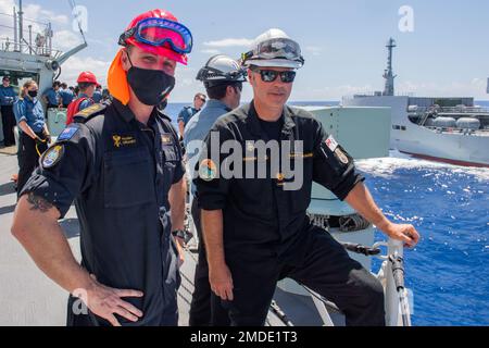 220722-O-QR492-1001-CA PAZIFIK (22. Juli 2022) Ein Matrose vom Hilfsölerauffüllungsschiff der Royal New Zealand Navy HMNZS Aotearoa (A 11), links, steht mit der Royal Canadian Navy Fregatte HMCS Vancouver (FFH 331) Chief Boatswain’s Mate CPO2 Shawn Mosson an Bord der Vancouver, 22. Juli 2022. Der Neuseeland Sailor kam an Bord der Königlichen Kanadischen Fregatte während einer Wiederauffüllung auf See (RAS) zwischen den beiden Schiffen während Rim of the Pacific (RIMPAC) 2022. Die Vancouver war das erste kanadische Schiff, das jemals eine RAS mit der Aotearoa durchführte. Sechsundzwanzig Nationen, 38 Überwasserschiffe, drei U-Boote, Ni Stockfoto
