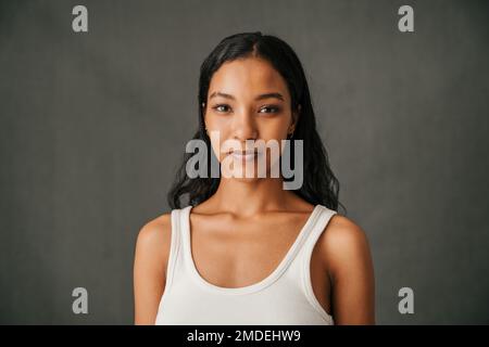 Nahaufnahme einer attraktiven, lächelnden, multiethnischen Frau im Studio Stockfoto