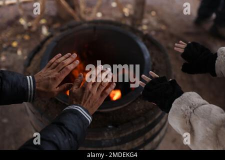 Mann und Frau wärmen ihre Hände über dem Feuer. Stockfoto