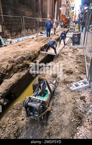 Handwerker, die in einem offenen Graben des historischen Viertels Centro an Rohren, Abwasserkanälen und Versorgungseinrichtungen arbeiten. In Neapel, Neapel, Italien, Italien. Stockfoto