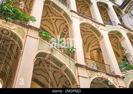 Der gelb-grüne Stuck, tropfende, kurvige Treppe am Palazzo dello Spagnolo. Entworfen vom barocken Architekten Ferdinando Sanfelice. In Neapel Stockfoto