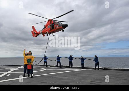 Crewmitglieder der Küstenwache Cutter Healy und der Luftwaffe Kodiak betanken am 22. Juli 2022 einen Hubschrauber in der Nähe des Polarkreises. Die Küstenwache nahm an Tag- und Nachtflügen mit zwei MH-65 Dolphin Helikoptern Teil. USA Hilfsfoto der Küstenwache von Deborah Cordone. Stockfoto