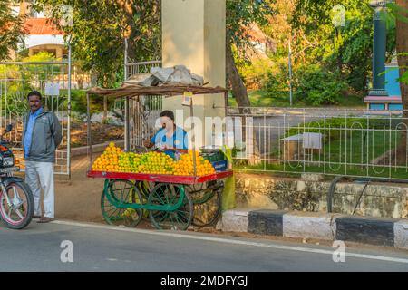 Puttaparthi, Andra Pradesh, Indien - 18,2023. Januar: Indischer Mann, der frischen Orangensaft auf der Straße in Puttaparthi verkauft Stockfoto