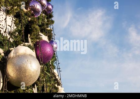 Dekorierter Weihnachtsbaum vor dem blauen Himmel aus nächster Nähe Stockfoto