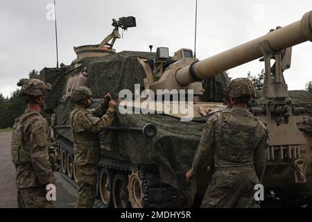 EIN US-AMERIKANISCHER Artilleriecrew, Alpha Battery zugeteilt, 3. Bataillon, 29. Artillerieregiment, 3. Panzerbrigade-Kampfteam, 4. Infanteriedivision, tarnt einen M109 Paladin-Haubitzer auf der vorderen Einsatzstelle Adazi, Lettland, 24. Juli 2022. Das 3/4. ABCT ist unter anderem der 1. Infanteriedivision zugewiesen und arbeitet stolz mit NATO-Verbündeten und regionalen Sicherheitspartnern zusammen, um Kampfkräfte für das V Corps, Amerikas vorwärtsgebrachtes Korps in Europa, bereitzustellen. Stockfoto