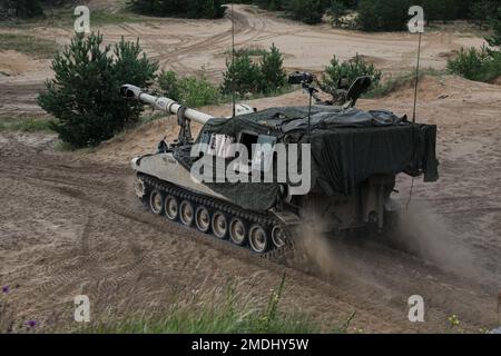 EIN US-AMERIKANISCHER Heer M109 Paladin-Howitzer, Alpha Battery zugeteilt, 3. Bataillon, 29. Artillerie-Regiment, 3. Panzerbrigade-Kampfteam, 4. Infanterie-Division, fährt zu ihrem Platz auf der Piste an der vorderen Einsatzstelle Adazi, Lettland, 24. Juli 2022. Das 3/4. ABCT ist unter anderem der 1. Infanteriedivision zugewiesen und arbeitet stolz mit NATO-Verbündeten und regionalen Sicherheitspartnern zusammen, um Kampfkräfte für das V Corps, Amerikas vorwärtsgebrachtes Korps in Europa, bereitzustellen. Stockfoto