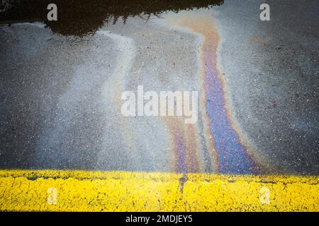 Bunte Ölflecken auf einer Asphaltstraße Stockfoto