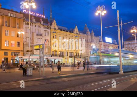 Kroatien, Zagreb, Straßenbahnen bei Nacht auf dem Hauptplatz - Trg Bana Jelacica. Stockfoto