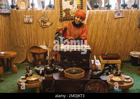 Schöne Frau, die im Kaffeemuseum Kaffee auf arabisch macht. Dubai. Vereinigte Arabische Emirate. VAE. 27. November 2022 Stockfoto