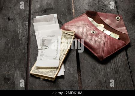 Ein Scheck aus dem Supermarkt mit Dollars liegt ein Husten mit Geld auf einem Holztisch im Licht zu Hause, Geld auf dem Tisch, finanzieren Stockfoto