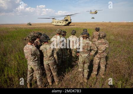 Delta Company zugeteilte Soldaten, 1. Bataillon, 502. Infanterieregiment ‚ERSTER ANGRIFF‘, 2. Brigaden-Kampfteam ‚ANGRIFF‘, 101. Luftangriff beobachten einen CH-47 Chinook-Hubschrauber, der Bravo Company zugeteilt wurde; 2. Battalion 227. Aviation Regiment ‚BLACKCATS‘, da es ein Mehrrad-Fahrzeug mit hoher Mobilität (HMMWV) während Aufzugsübungen am 25. Juli 2022 in Mihail Kogalniceanu, Rumänien, bewegt. . Wie schon in den letzten 80 Jahren steht die 101. Luftangriffe-Division bereit, die Nation und unsere Alliierten überall zu unterstützen und zu verteidigen. (USA Militärfotos von Staff Sgt. MA Stockfoto