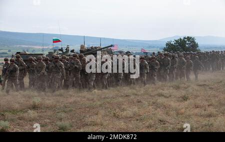 USA Soldaten der Bravo Company, 1. Bataillon, 8. Infanterie-Regiment, 3. Bewaffnete Brigaden-Kampfeinheit, 4. Infanterie-Division; 2. Bataillon, 4. Sicherheitseinsatzbrigade; bulgarische Soldaten 42. Mechanisierten Bataillons zugewiesen, 2. Mechanisierte Brigade; Und britische Soldaten, die der Charlie Company zugeteilt wurden, 1. Bataillon, 1. Königliches irisches Regiment, marschieren gemeinsam nach Abschluss der Eröffnungszeremonie von Übung Platinum Lion 22 in Novo Selo Trainingsgebiet, Bulgarien, 25. Juli 2022. Exercise Platinum Lion ist eine multinationale Übung, die von Bulgaren veranstaltet wird, um die Arbeit zu verbessern Stockfoto