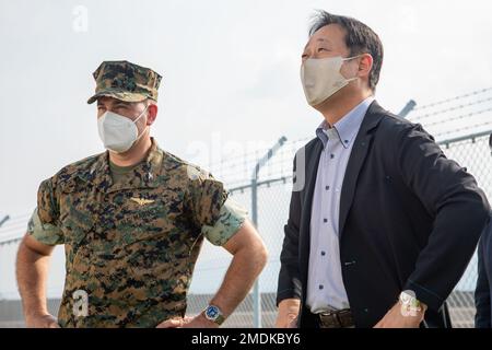 USA Marinekorps Oberst Richard Rusnok, kommandierender Offizier der Marinekorps-Luftwaffenstützpunkt Iwakuni, Left, und Yoshihiko Fukuda, Bürgermeister von Iwakuni City, sprechen während eines Installationsbesuchs in MCAS Iwakuni, Japan, 25. Juli 2022. Zweck des Besuchs war es, die Funktionen des Northrop Grumman MQ-4C Triton, eines unbesetzten, langlebigen amerikanischen Hochleistungsflugzeugs, und seine kürzliche Ankunft im MCAS Iwakuni zu erörtern. Stockfoto