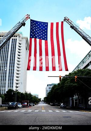 Die amerikanische Flagge wird am 26. Juli 2022 in Montgomery, Alabama, vor dem Rathaus von Montgomery angebracht. Eine Zeremonie wurde zu Ehren der 102-jährigen Veteranen des Zweiten Weltkriegs Romay Davis für ihren Dienst als Mitglied des 6888. Central Postal Directory Bataillons abgehalten. Die rein weibliche und rein schwarze Einheit erhielt die Congressional Gold Medal von Präsident Joe Biden und die Zeremonie fand am 74. Jahrestag des Armed Forces Women’s Integration Act statt. 22. Luftwaffe, Air Mobility Command, Maxwell Air Force Base, USNORTHCOM, USTRANSCOM, Air Force Reserve Command, Stockfoto
