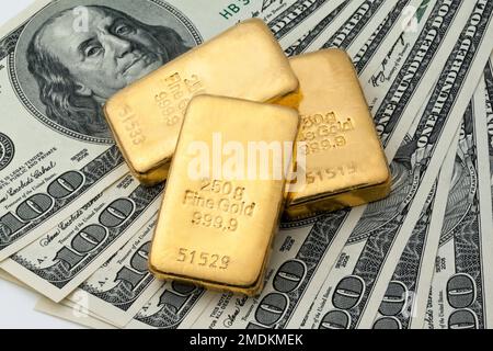 Goldbarren auf 100-Dollar-Scheinen Stockfoto