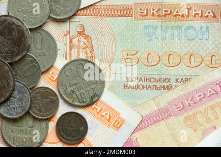 Auf dem Tisch liegen die Währungseinheit des ukrainischen Staates Kupon und Münzen der udssr, altes sowjetisches Geld, Münzen und Kupons, Finanzen Stockfoto