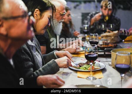 Glückliche Familie trinkt Rotwein beim Barbecue-Abendessen im Freien - verschiedene Altersstufen der Leute, die Spaß am Wochenende haben Stockfoto