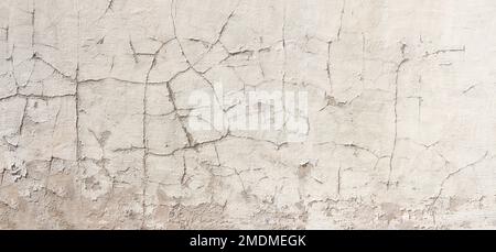 Alte Wand mit Rissen im verwitterten, hellen Putz Stockfoto