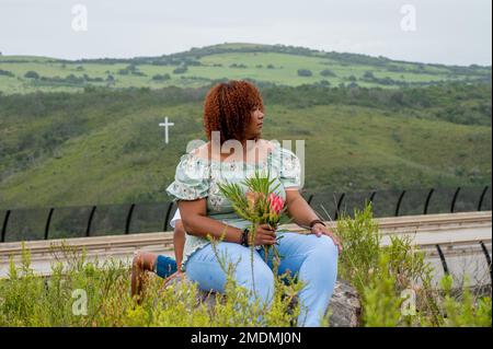 Porträt einer Frau, die in der Natur sitzt Stockfoto