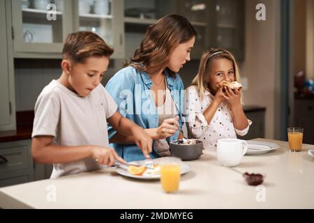 Viel Spaß nach dem Frühstück. Eine junge Familie, die zu Hause frühstückt. Stockfoto