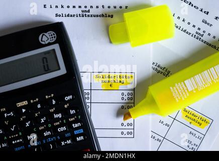 München, Deutschland. 23. Januar 2023. Das Wort „Solidaritätszuschlag“ ist neben einem Rechner und einem Textmarker auf einer Steuererklärung zu sehen. Kredit: Sven Hoppe/dpa/Alamy Live News Stockfoto