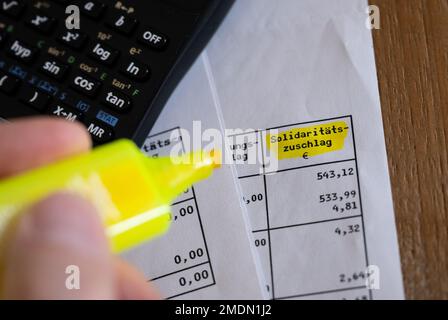 München, Deutschland. 23. Januar 2023. Das Wort „Solidaritätszuschlag“ ist neben einem Rechner und einem Textmarker auf einer Steuererklärung zu sehen. Kredit: Sven Hoppe/dpa/Alamy Live News Stockfoto