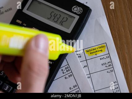 München, Deutschland. 23. Januar 2023. Das Wort „Solidaritätszuschlag“ ist neben einem Rechner und einem Textmarker auf einer Steuererklärung zu sehen. Kredit: Sven Hoppe/dpa/Alamy Live News Stockfoto