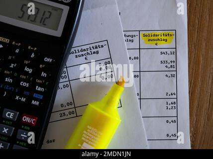 München, Deutschland. 23. Januar 2023. Das Wort „Solidaritätszuschlag“ ist neben einem Rechner und einem Textmarker auf einer Steuererklärung zu sehen. Kredit: Sven Hoppe/dpa/Alamy Live News Stockfoto