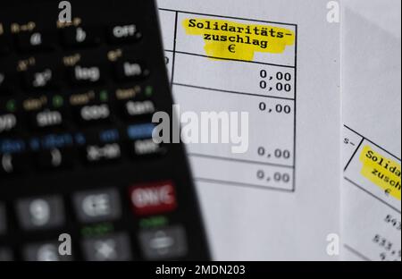 München, Deutschland. 23. Januar 2023. Das Wort „Solidaritätszuschlag“ wird neben einem Rechner auf einer Steuererklärung angezeigt. Kredit: Sven Hoppe/dpa/Alamy Live News Stockfoto