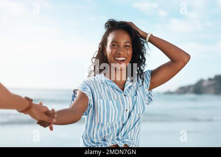 Folgen Sie mir zu vielen sonnigen Tagen. POV-Foto einer jungen Frau, die ihre Freunde am Strand hält. Stockfoto