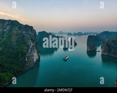 Verträumt Sonnenuntergang unter den Felsen der Halong Bay, Vietnam Stockfoto