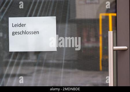 München, Deutschland. 23. Januar 2023. Ein Schild mit der Aufschrift „Bedauerlicherweise geschlossen“ hängt am Eingang eines geschlossenen Ladengeschäfts in der Innenstadt. Kredit: Peter Kneffel/dpa/Alamy Live News Stockfoto