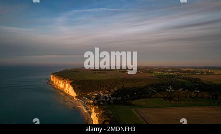 Dieser Drohnenschuss fängt die Schönheit von Les Petites Dalles in der Normandie in Frankreich zur goldenen Stunde ein, mit dem Ärmelkanal und der steilen Küste im Hintergrund Stockfoto