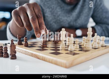 Du gewinnst nur, wenn du deine Gegner als Nächstes kennst. Ein unbekannter Geschäftsmann, der in seinem Büro Schach spielt. Stockfoto
